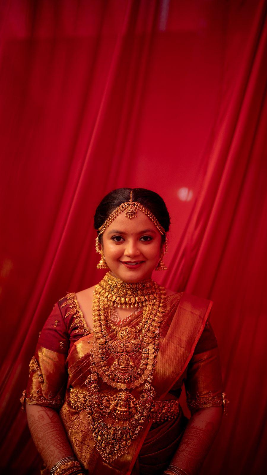 Ambika glimpsed through the red veil, in temple gold