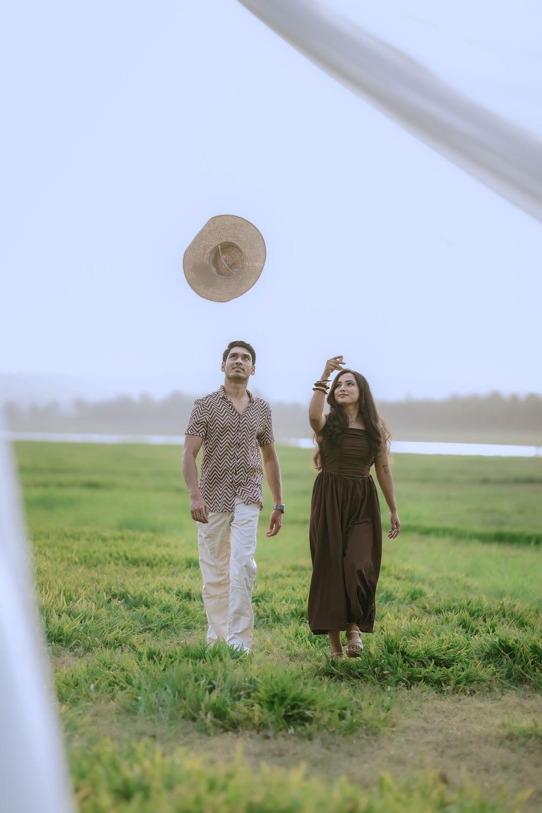 Apeksha and Rakshit walking through a misty lakeside field at dawn
