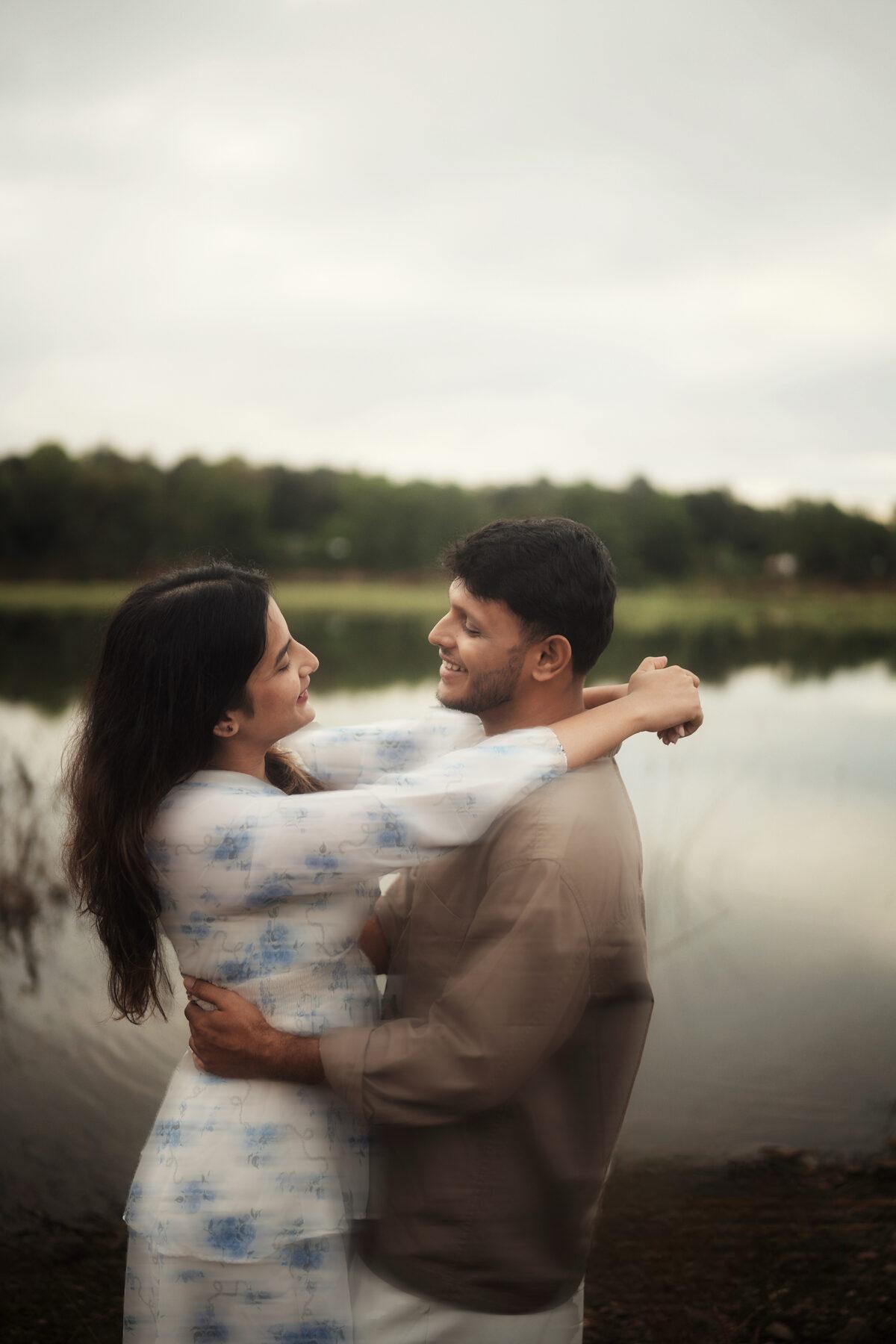 Apoorva and Deepak laughing by the still lake
