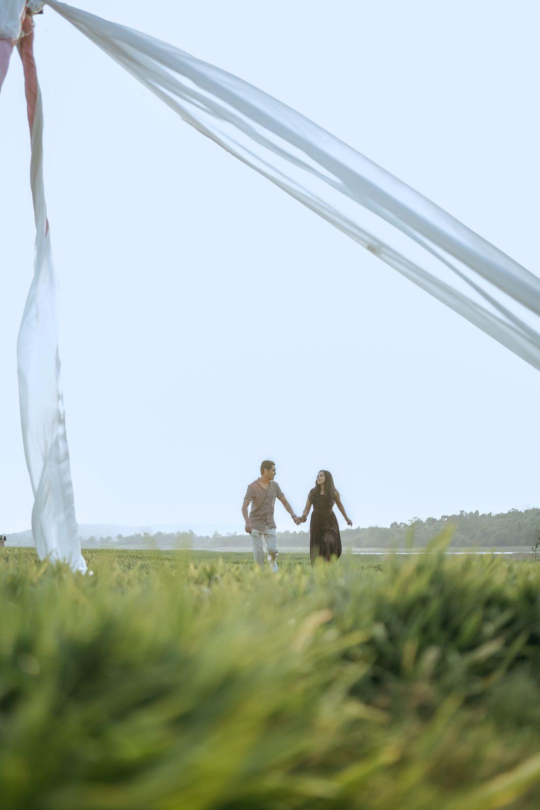 The couple in the distance, hand in hand by the lake