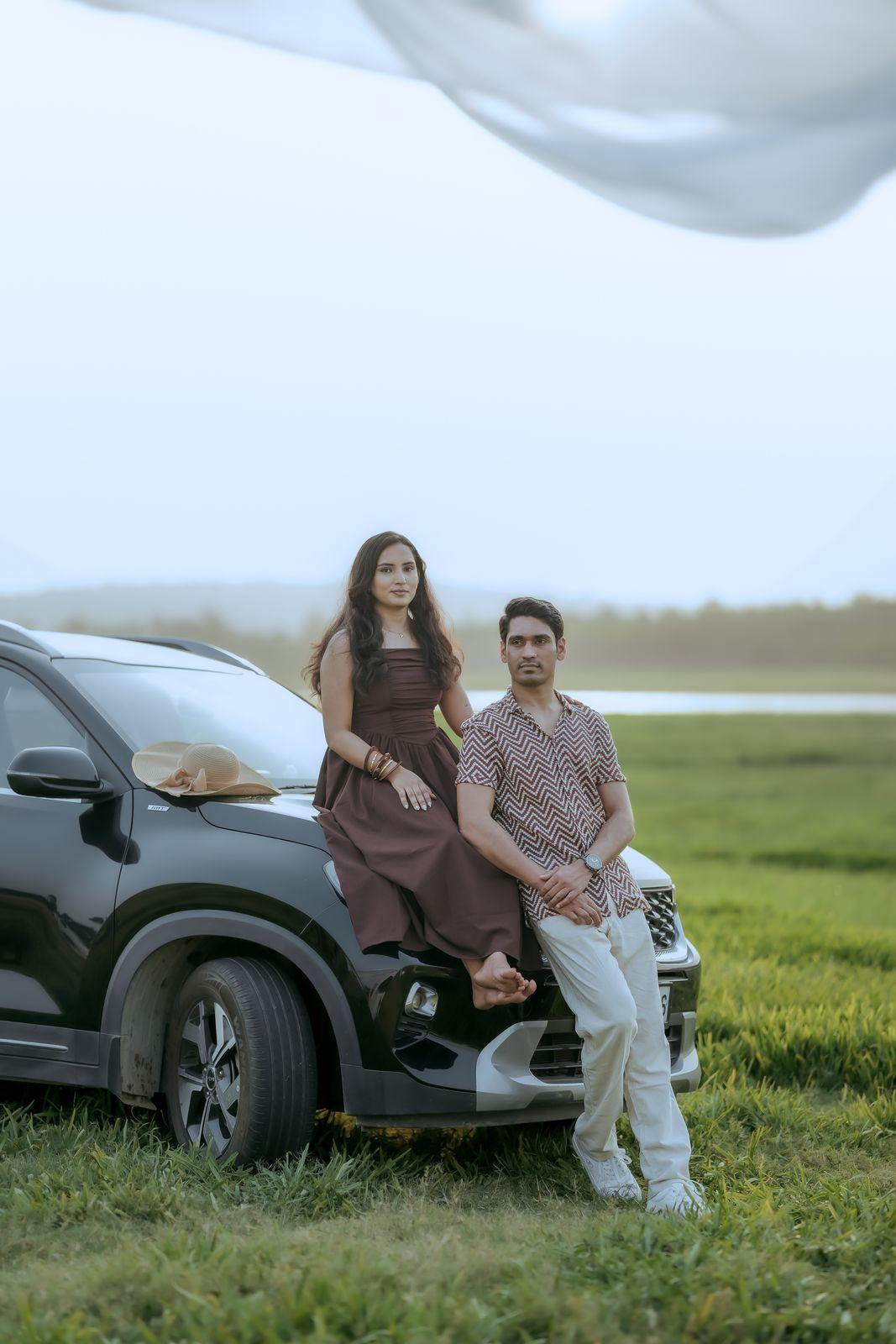 Apeksha and Rakshit seated by the car in the field