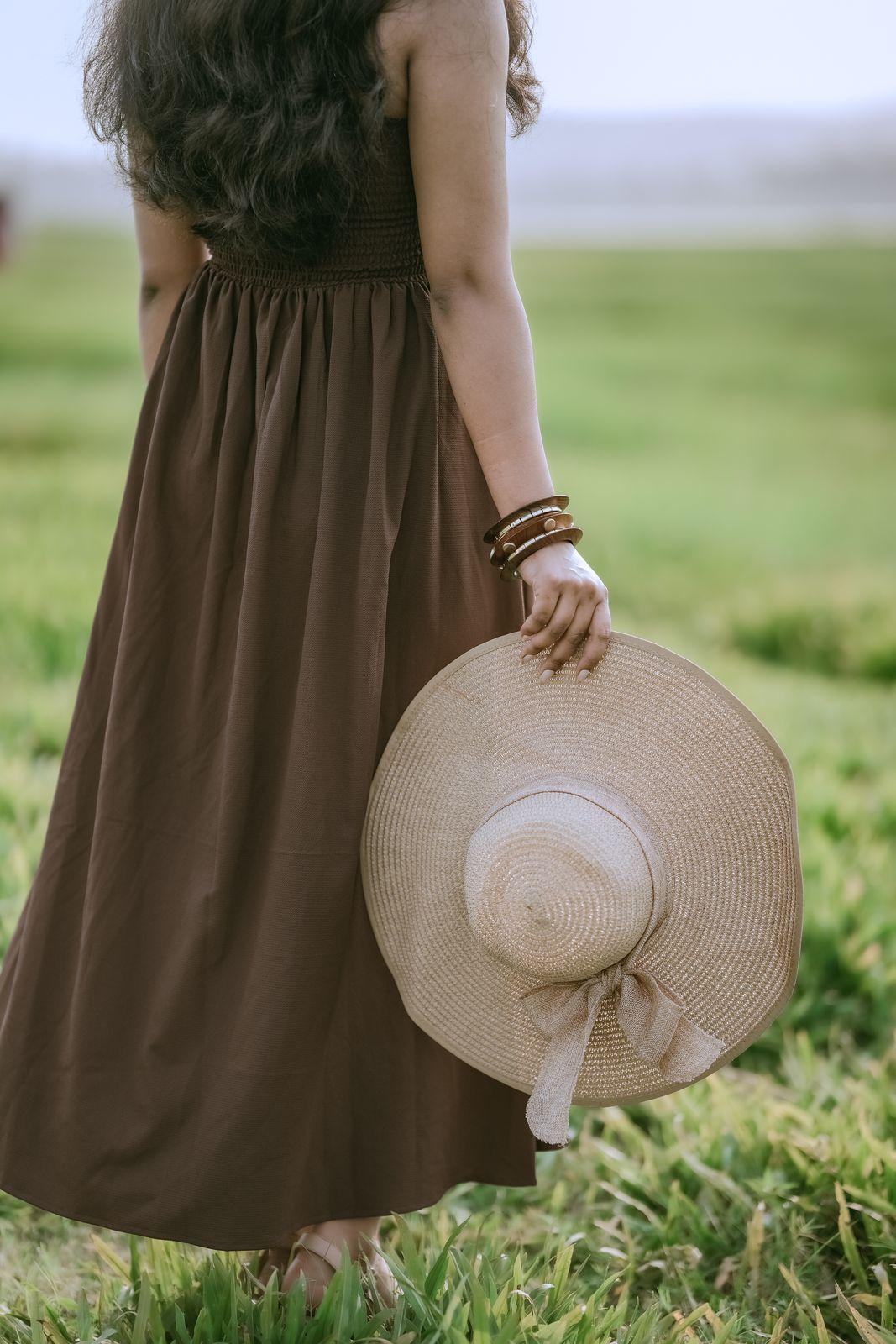 Apeksha holding her sun hat, a quiet portrait