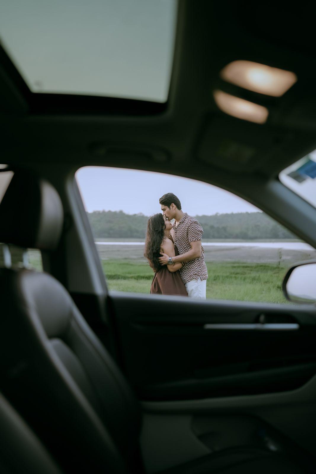 The couple reflected in the car in warm light